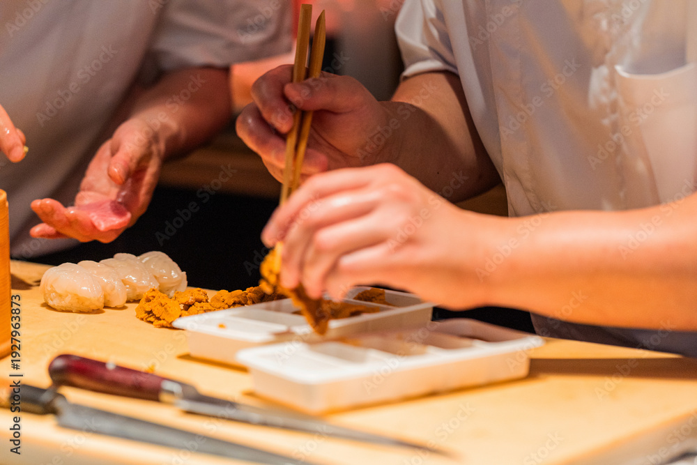 Obraz premium Skilled chef preparing sushi with fresh ingredients and precise techniques