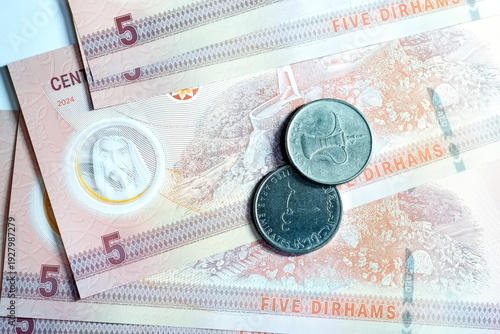 Close-up of United Arab Emirates Currency: AED Banknotes and Dirham Coins Scattered on Surface