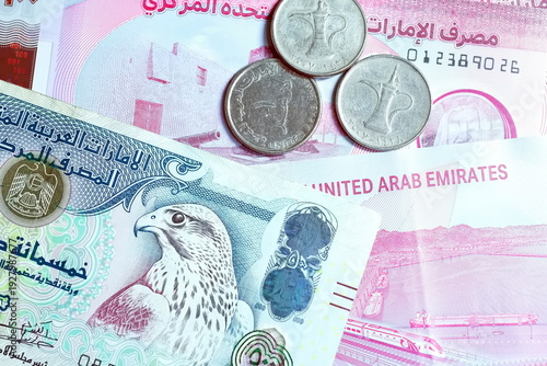Close-up of United Arab Emirates Currency: AED Banknotes and Dirham Coins Scattered on Surface