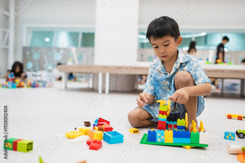 Adorable little school boy enjoy construction toy block building