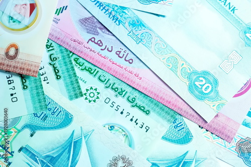 Close-up of United Arab Emirates Currency: AED Banknotes and Dirham Coins Scattered on Surface