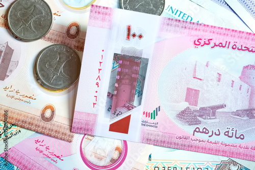Close-up of United Arab Emirates Currency: AED Banknotes and Dirham Coins Scattered on Surface