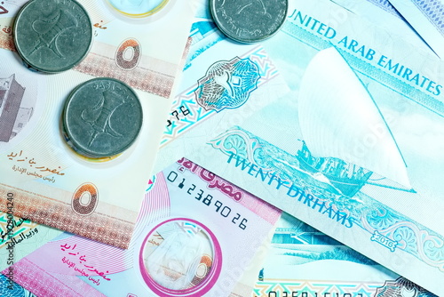 Close-up of United Arab Emirates Currency: AED Banknotes and Dirham Coins Scattered on Surface