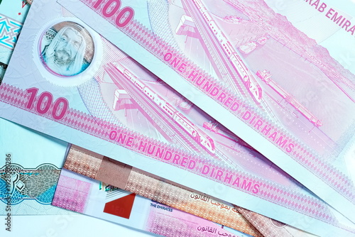 Close-up of United Arab Emirates Currency: AED Banknotes and Dirham Coins Scattered on Surface