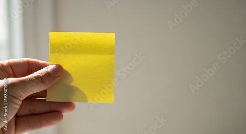 Wallpaper Mural Hand Grabs A Yellow Note for Inspiring Creativity. Torontodigital.ca