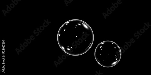 Two transparent soap bubbles of different sizes with white light reflections on a black background.