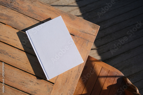 book mockup on wooden outdoor coffee table , hard light
