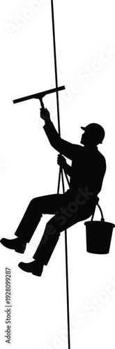 Professional Silhouette of a Window Washer Hanging on a Rope with a Squeegee and Bucket Working on a High Rise Building Exterior for Maintenance
