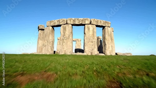 Ancient Stonehenge Prehistoric Stone Circle Monument Reflected in Tranquil Water on a Clear Blue Sky Day Salisbury Plain England