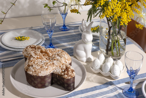 Fotografie Easter table decorated with colomba di pasqua cake, decorative bunny, speckled e