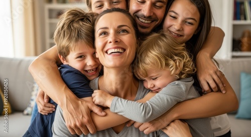 Happy parents and children embracing tightly together in a warm indoor setting