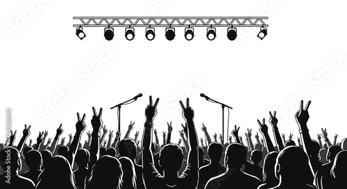 Concert crowd with raised hands under stage lights.