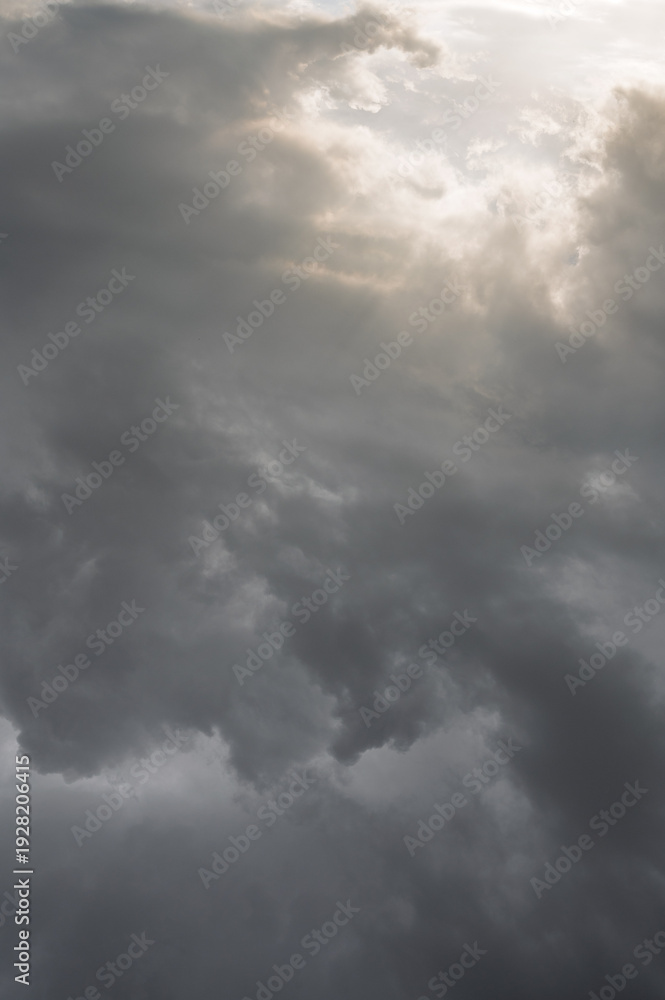 Fototapeta premium Dramatic sunset sky with dark storm clouds and soft light, moody atmosphere before rainfall