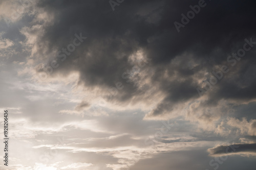 Dramatic sunset sky with dark storm clouds and soft light, moody atmosphere before rainfall