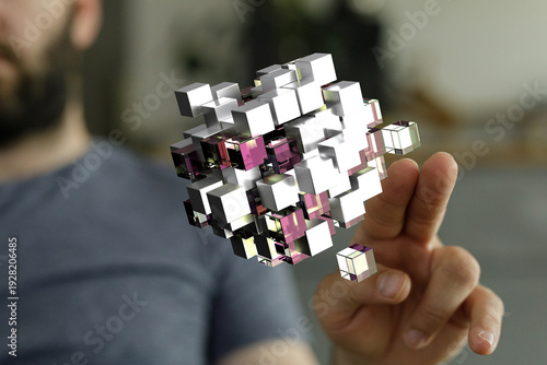 Close up of a man holding a 3D digital cube. Illustrates technology, innovation, and digital transformation concepts.