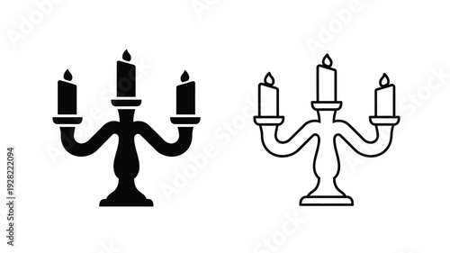 Two ornate candleholders with lit candles a striking black silhouette
