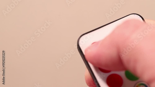 Macro close-up of a finger pressing the red ON button on a remote control.