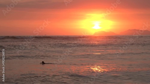 Wallpaper Mural Surfer paddles through the Pacific ocean waves at sunset in of Lima, Peru Torontodigital.ca