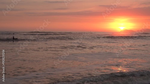 Wallpaper Mural Surfer paddles through the Pacific ocean waves at sunset in of Lima, Peru Torontodigital.ca