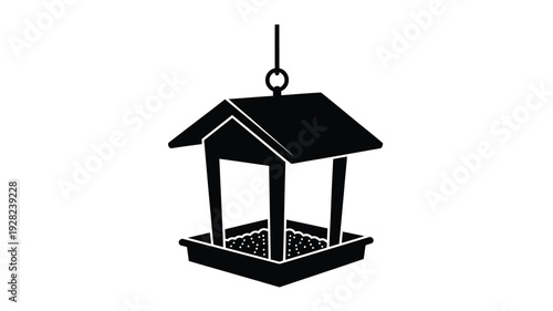 Black bird feeder hanging from a loop a striking silhouette