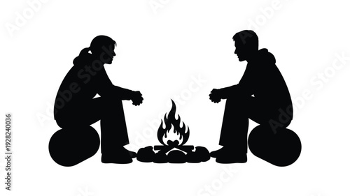 Two people sit by a campfire enjoying a quiet evening silhouette