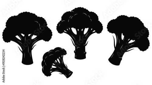 Four broccoli florets displayed as a striking black silhouette