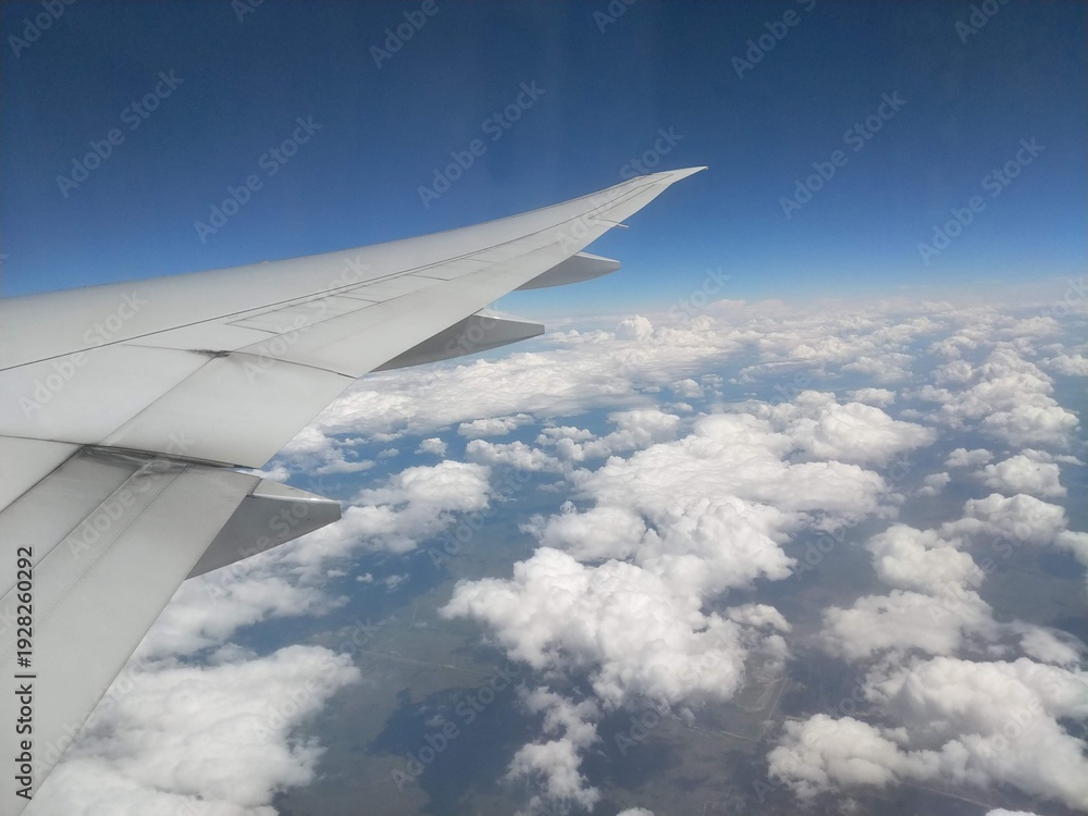 Obraz premium View from Airplane Window of Wing Over Vast White Cloud Formations