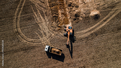 excavator loads truck aerial view from above with drone