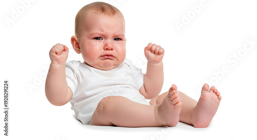 A baby sitting on a white floor with fists clenched and a stern expression