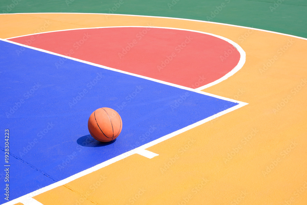 Fototapeta premium Basketball on colorful outdoor sport court surface, Sports field background with copy space