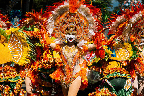 Cebu City, Philippines - 18 January 2026: View of vibrant Sinulog dancers adorned in elaborate costumes, a kaleidoscope of orange, white and gold, moving with rhythmic energy.
