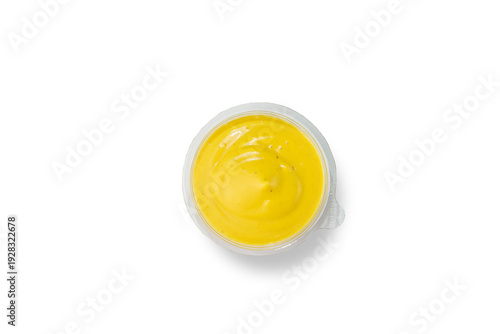 Smooth creamy yellow cheese sauce in small plastic cup isolated on white background top view fast food dipping sauce concept