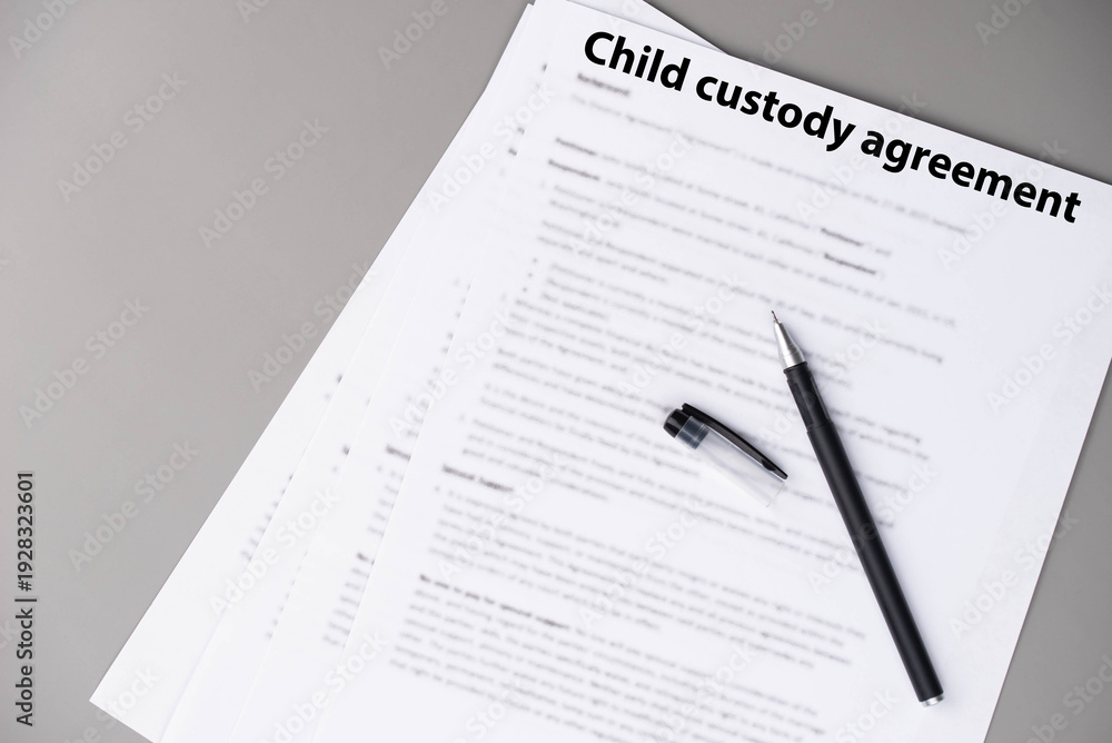 Obraz premium Child custody agreement document on table, legal paperwork for parental rights, divorce settlement, and family law concept.