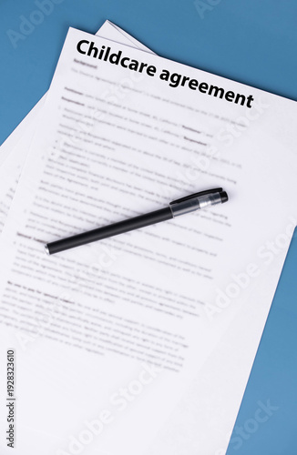 Childcare agreement contract on desk, legal document about child care services, parental responsibilities, and family support concept.