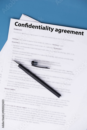 Confidentiality agreement document on office desk, legal contract for business privacy, nondisclosure and corporate security concept.