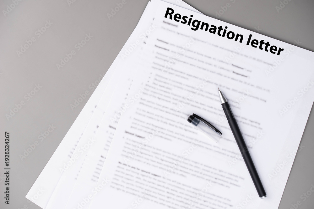 Obraz premium Resignation letter on office desk, formal document where employee voluntarily leaves job, symbol of professional change, career transition, and emotional decision at workplace.