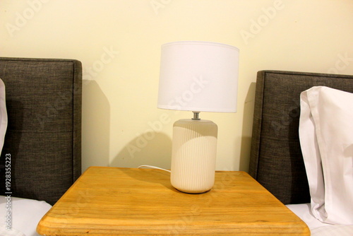 Brown wooden bedside table with beds on both sides
