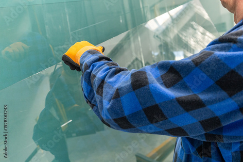 Schilderij op canvas The glassmaker lifts a pane of glass from a stand in a glassworks