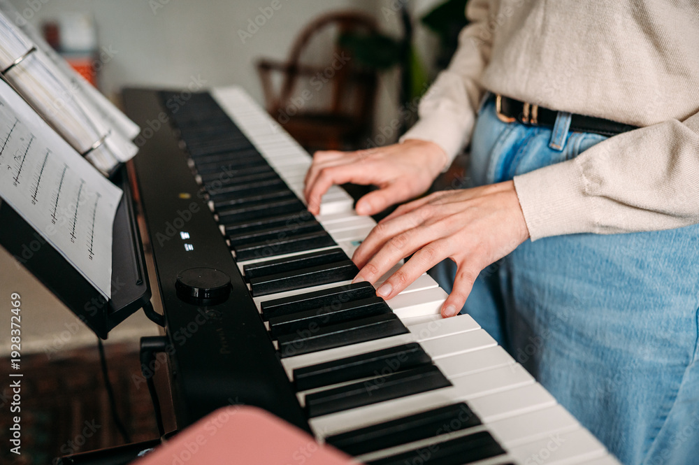 Obraz premium Practicing piano with sheet music on digital keyboard