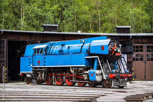 a lady in a white blouse shows a picture to a little girl