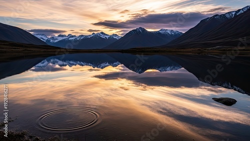 A serene lake reflects the vibrant colors of a mountain sunset