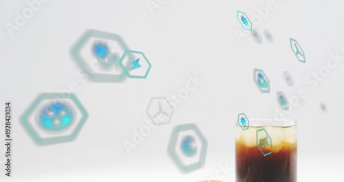 Showing glass holding iced coffee, amber-top, cookie, teal hexagons on studio tabletop, copy space