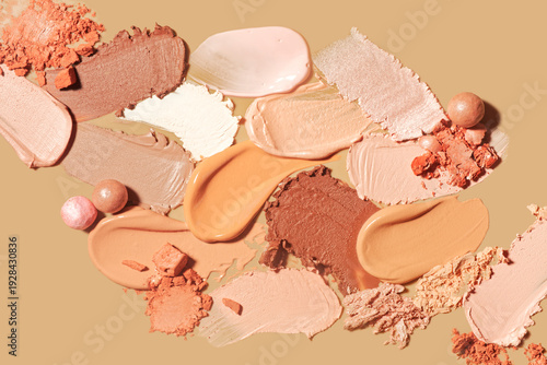 Set of different textures of cosmetic foundation, concealer, highlighter, soft powder, bronzer, on beige background
