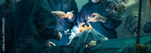 Surgeons, dressed in blue sterile gowns, perform a knee replacement using a robotic-assisted system, showcasing precision and teamwork in a modern operating room filled with advanced technology
