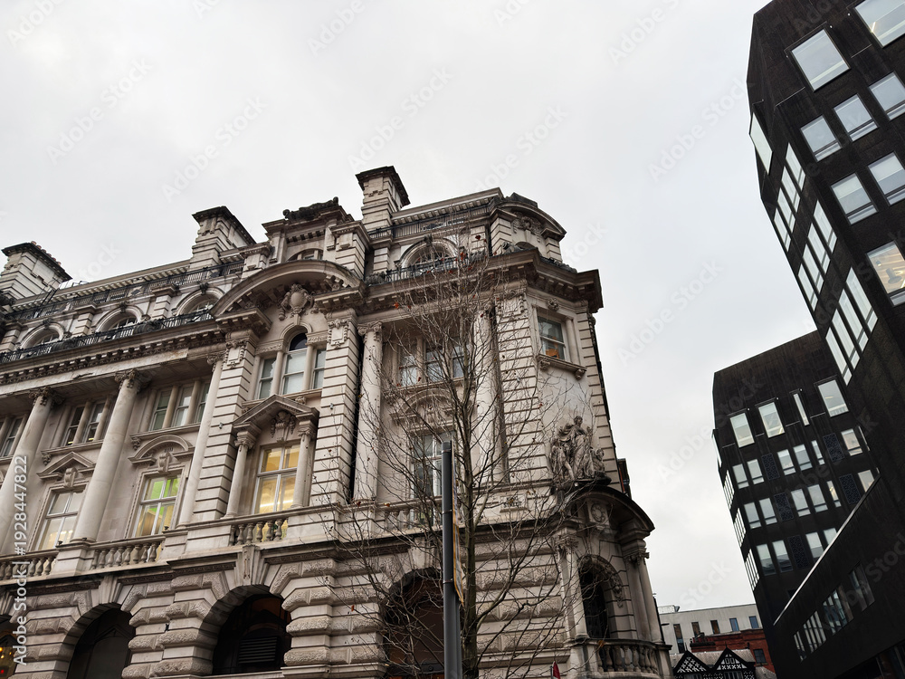 Naklejka premium Historic city hall style building in Manchester with modern high rise nearby in city center