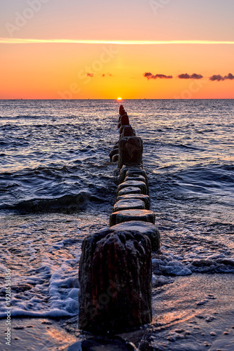 Golden Sunset over Wooden Groynes on the Baltic Sea Coast
