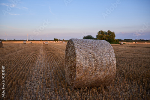 Golden Hour Hay Bales and Wind Turbines in Rural German Landscape