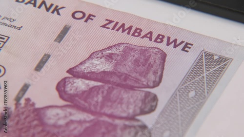 Reserve bank of Zimbabwe in Southern South Africa with inflation and inflated economy of printed cash dollar bills in thoughts, billions, and millions of dollars bill on paper surface in old Rhodesia