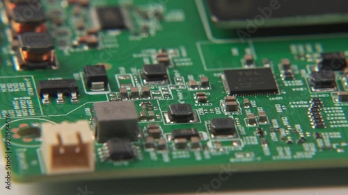 Close up slow motion of exposed green television TV electronics internal mother board motherboard with solder, ports, and screws spinning on damaged computer parts for 4k home display open for repair