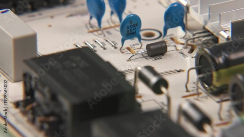 Close up slow motion of TV television video power supply electronic electronics board for internal media with transisteos, transformers, heat sink, and small wires and cables attached to inside device
